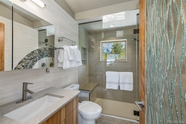 551 Spade Pl, Jefferson, CO 80456 - full bathroom featuring tile walls, tiled shower, vanity, and toilet
