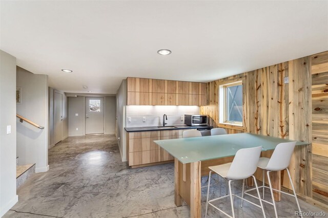 551 Spade Pl, Jefferson, CO 80456 - kitchen with stainless steel microwave, modern cabinets, light brown cabinetry, wood walls, and a sink