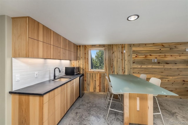 551 Spade Pl, Jefferson, CO 80456 - kitchen with a sink, appliances with stainless steel finishes, a kitchen bar, modern cabinets, and concrete floors