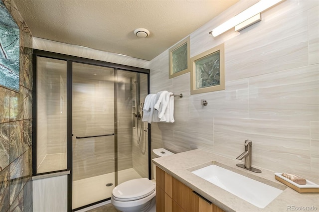 551 Spade Pl, Jefferson, CO 80456 - bathroom featuring tile walls, vanity, toilet, a stall shower, and tasteful backsplash