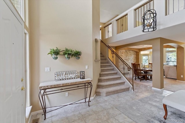 12671 Home Farm Ln, Westminster, CO 80234 - entryway with arched walkways, a towering ceiling, stairway, and baseboards