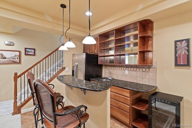 12671 Home Farm Ln, Westminster, CO 80234 - kitchen with open shelves, stainless steel fridge, a sink, tasteful backsplash, and a kitchen breakfast bar