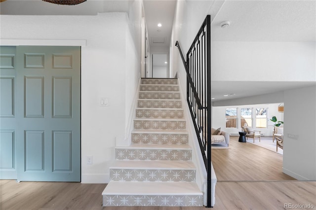 staircase with hardwood / wood-style floors