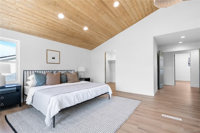 bedroom with a spacious closet, high vaulted ceiling, light hardwood / wood-style flooring, and wooden ceiling