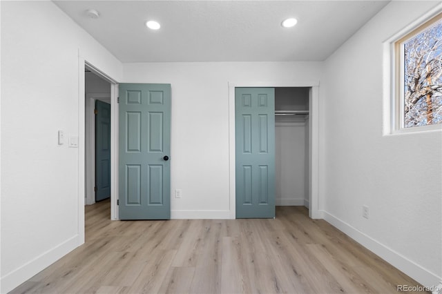 unfurnished bedroom with a closet and light wood-type flooring