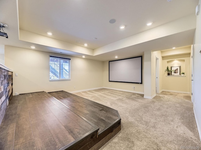 cinema room with a tray ceiling and carpet floors