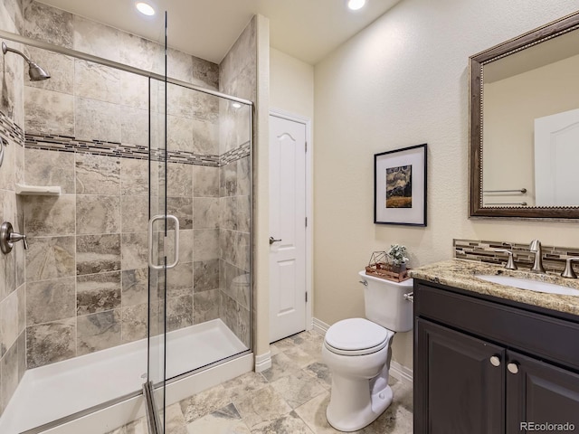 bathroom featuring vanity, toilet, and an enclosed shower