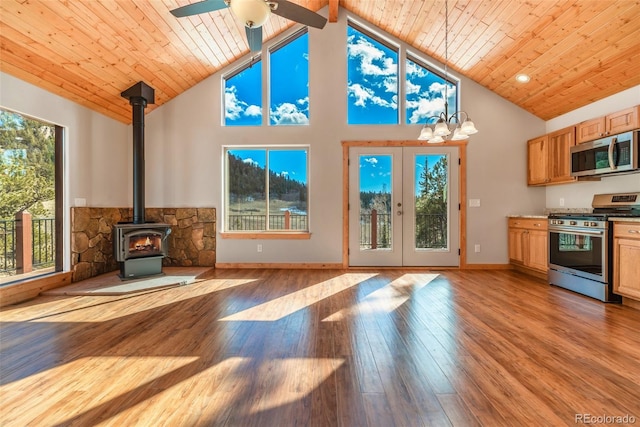 interior space with high vaulted ceiling, light hardwood / wood-style floors, wooden ceiling, french doors, and a wood stove