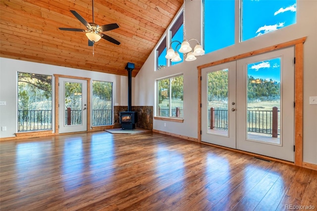 unfurnished living room featuring high vaulted ceiling, wood-type flooring, a wood stove, wood ceiling, and french doors