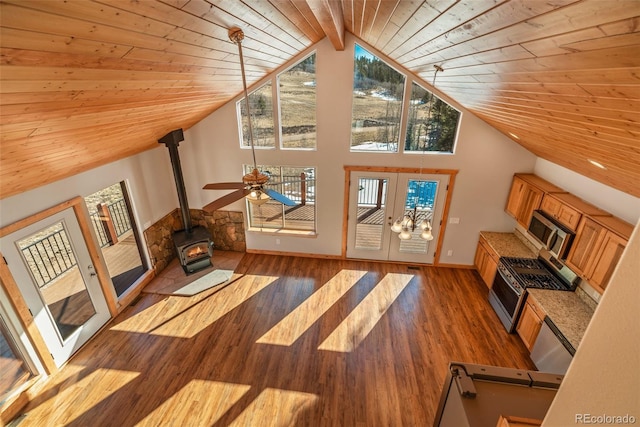 living room featuring hardwood / wood-style floors, high vaulted ceiling, a wood stove, wooden ceiling, and french doors