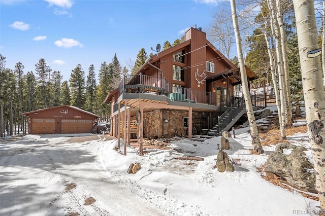 exterior space featuring an outdoor structure, stairway, a deck, and a garage