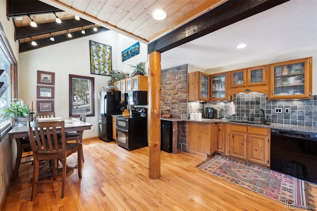 266 Lodgepole Dr, Evergreen, CO 80439 - kitchen with a sink, stone countertops, brown cabinetry, black appliances, and glass insert cabinets