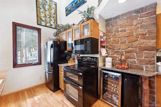 266 Lodgepole Dr, Evergreen, CO 80439 - kitchen with light wood finished floors, beverage cooler, glass insert cabinets, light stone countertops, and black appliances