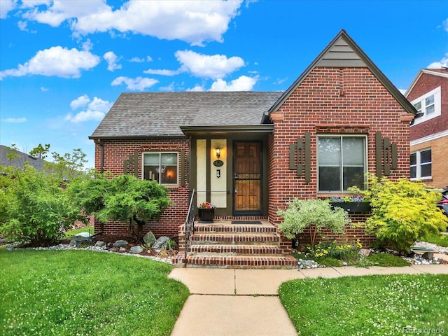 1247 Dexter St, Denver, CO 80220 - view of front of property featuring brick siding, a shingled roof, and a front lawn