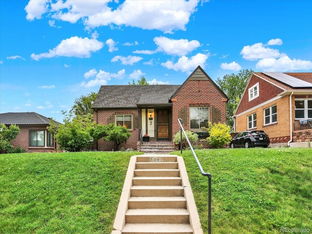 1247 Dexter St, Denver, CO 80220 - tudor home with brick siding, a front yard, and roof with shingles