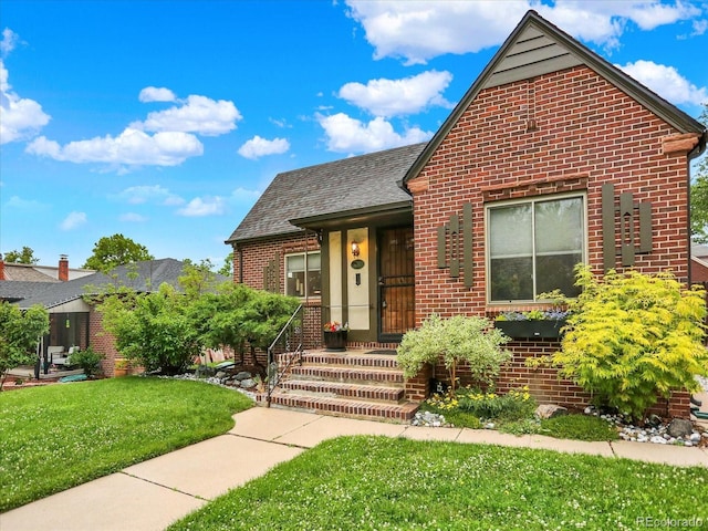1247 Dexter St, Denver, CO 80220 - view of front of house with brick siding, a front yard, and a shingled roof