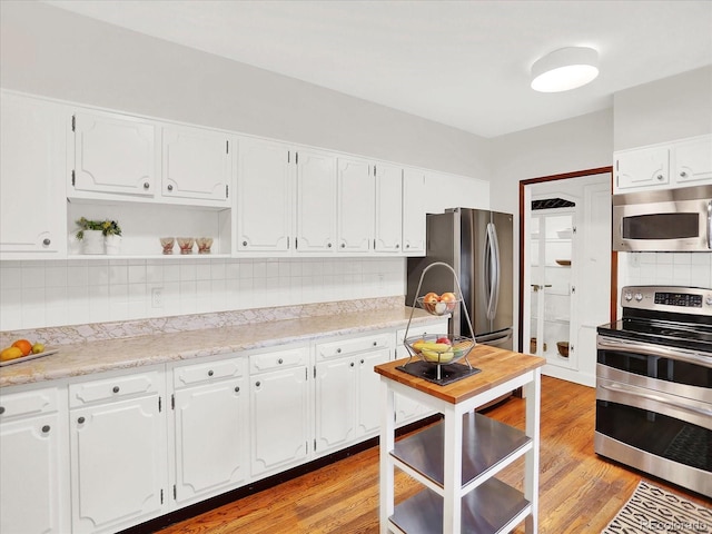 1247 Dexter St, Denver, CO 80220 - kitchen with stainless steel appliances, backsplash, open shelves, light countertops, and white cabinetry