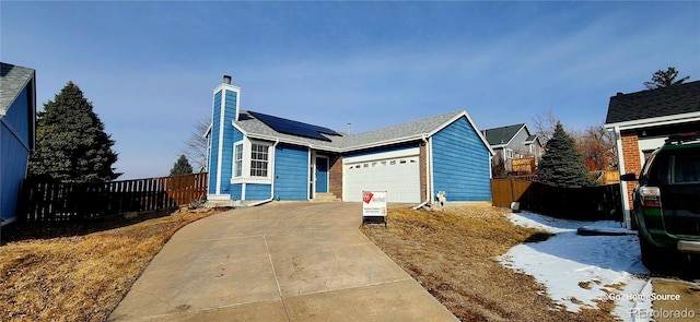 view of front of home featuring a garage and solar panels