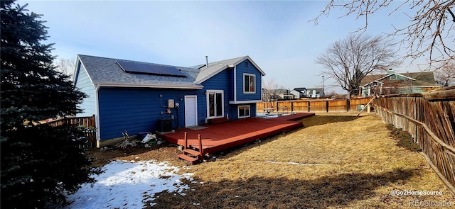 back of house featuring solar panels, a deck, and central AC