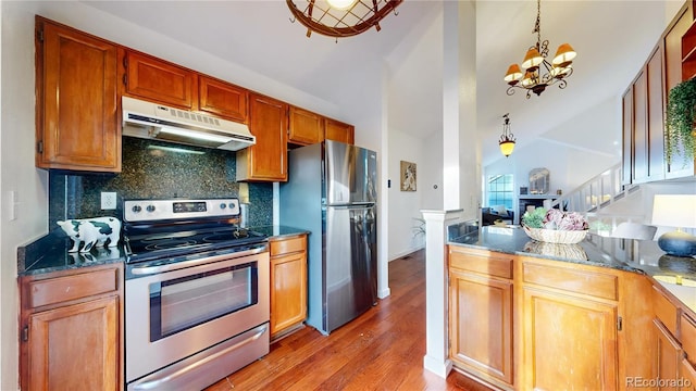 1265 Iris Ct, Highlands Ranch, CO 80126 - kitchen with appliances with stainless steel finishes, under cabinet range hood, wood finished floors, tasteful backsplash, and a chandelier