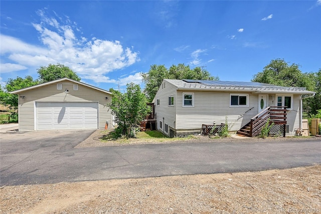 3145 S Bryant St, Sheridan, CO 80110 - view of front of house featuring a garage, solar panels, and an outdoor structure