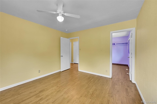 3145 S Bryant St, Sheridan, CO 80110 - unfurnished bedroom featuring light wood-style flooring, a walk in closet, ceiling fan, and a closet