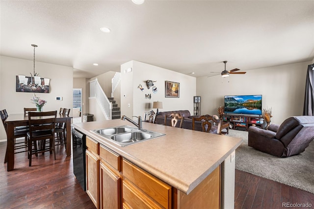 kitchen with a sink, black dishwasher, dark wood-style flooring, and open floor plan