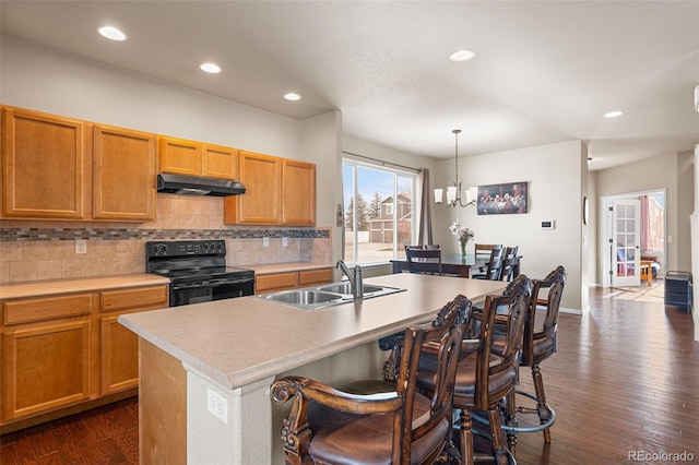 kitchen with a sink, black range with electric cooktop, under cabinet range hood, and tasteful backsplash