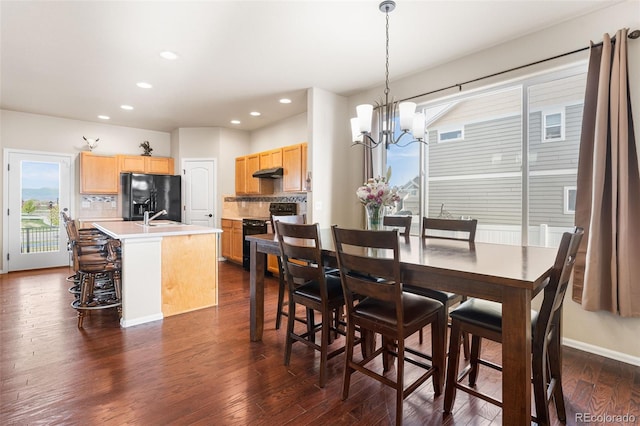 dining area with recessed lighting, an inviting chandelier, plenty of natural light, and dark wood-type flooring