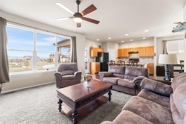 carpeted living area featuring a ceiling fan, baseboards, and recessed lighting