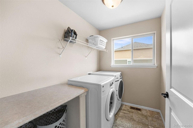 washroom featuring baseboards, visible vents, laundry area, and washer and clothes dryer