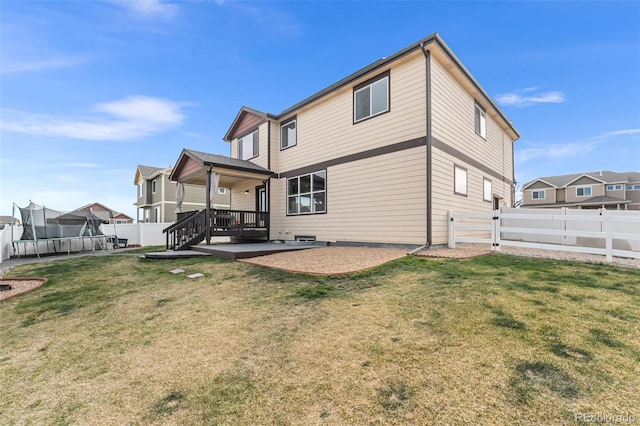 rear view of house featuring a lawn, a fenced backyard, a trampoline, and a patio area