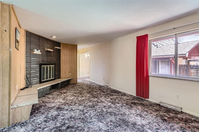 unfurnished living room featuring visible vents, carpet floors, baseboards, and a fireplace