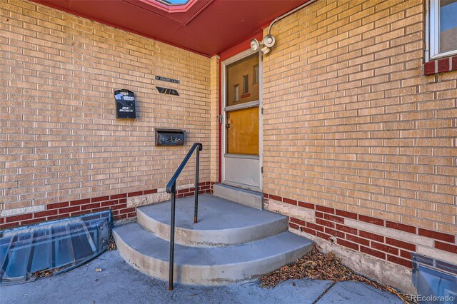 view of exterior entry featuring brick siding