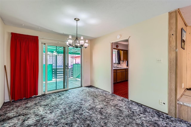 unfurnished room featuring an inviting chandelier, carpet, and a sink