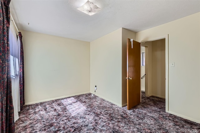 carpeted empty room with baseboards