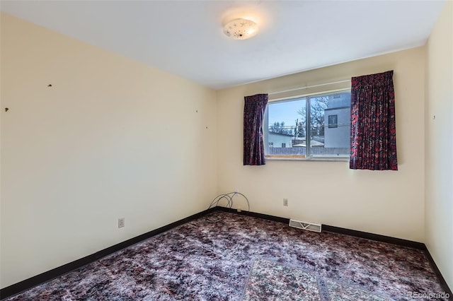 spare room with visible vents, baseboards, and carpet flooring