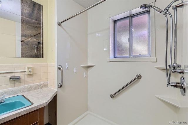 full bath featuring decorative backsplash, walk in shower, and vanity