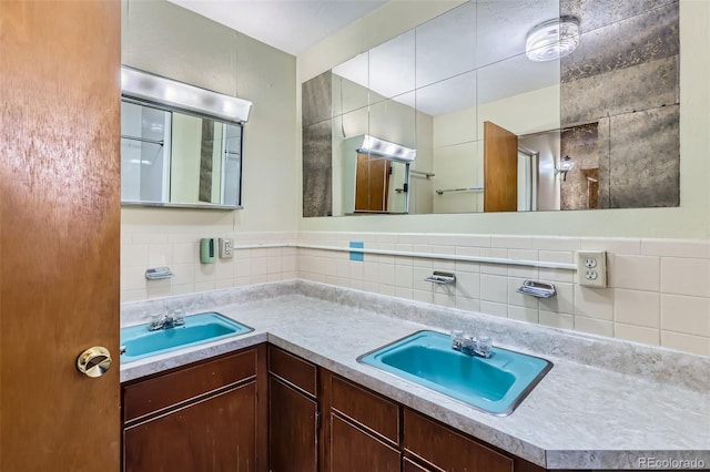 bathroom with double vanity, tasteful backsplash, tile walls, and a sink