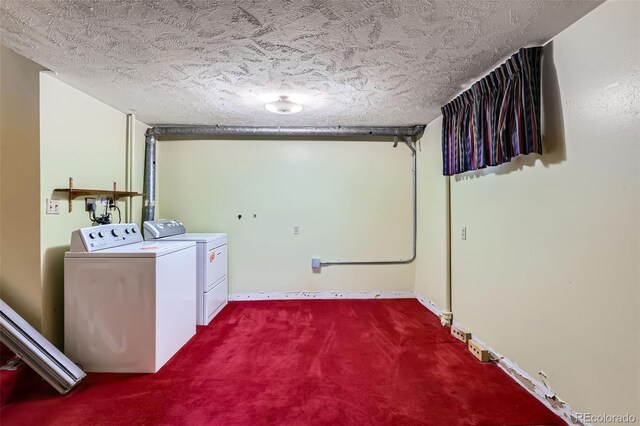 laundry room featuring baseboards, washing machine and clothes dryer, laundry area, a textured ceiling, and dark carpet