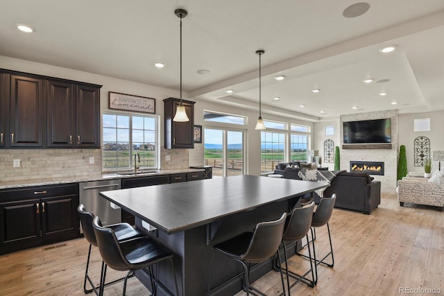16002 E 111th Cir, Commerce City, CO 80022 - kitchen with stainless steel dishwasher, a sink, tasteful backsplash, light wood-style flooring, and a tray ceiling