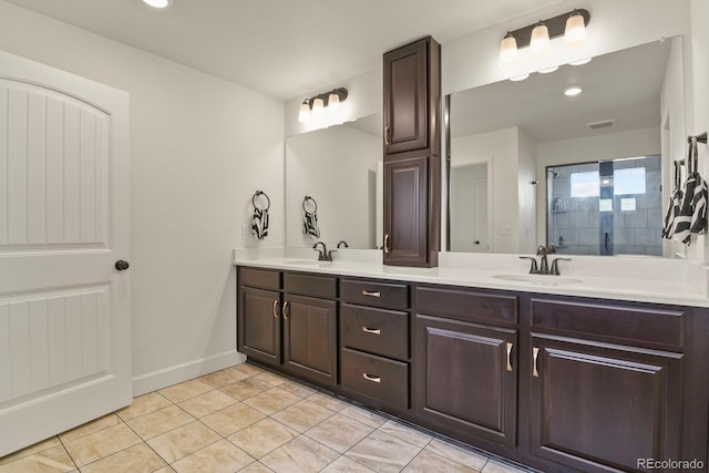16002 E 111th Cir, Commerce City, CO 80022 - bathroom with tile patterned flooring, double vanity, tiled shower, recessed lighting, and baseboards