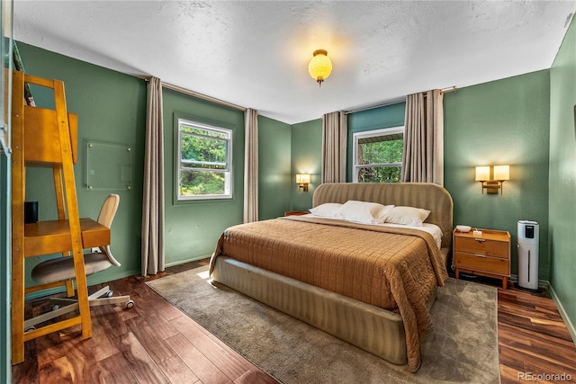 6549 Modoc Ln, Evergreen, CO 80439 - bedroom featuring wood finished floors, multiple windows, and a textured ceiling