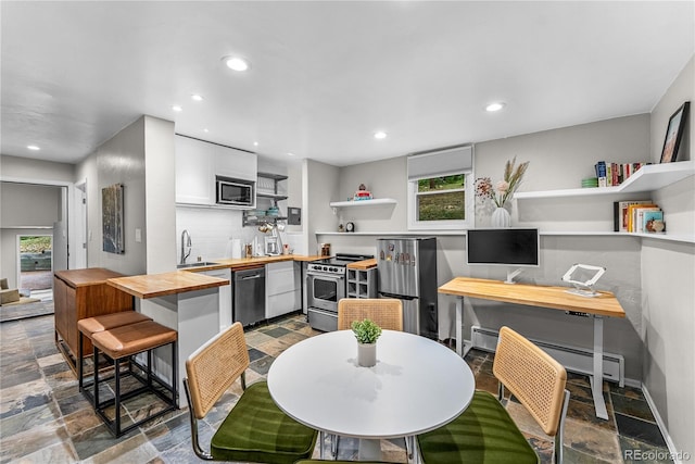 6549 Modoc Ln, Evergreen, CO 80439 - kitchen with butcher block countertops, open shelves, stainless steel appliances, stone tile floors, and white cabinets