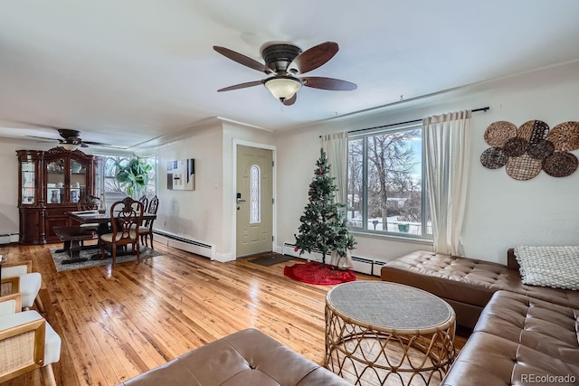 living area featuring hardwood / wood-style floors, baseboards, a baseboard heating unit, and ceiling fan