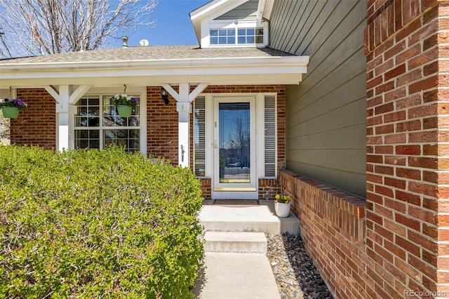 doorway to property featuring brick siding and covered porch