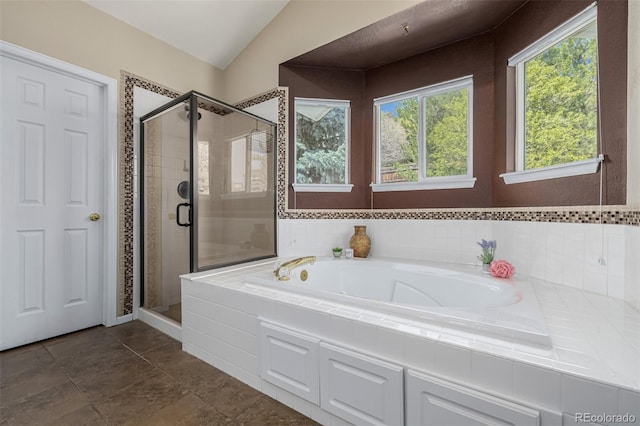 bathroom featuring a shower stall, a garden tub, and vaulted ceiling
