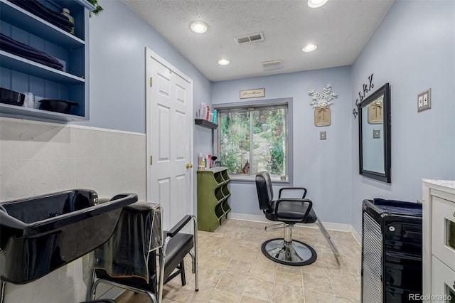 home office with a textured ceiling, recessed lighting, and tile walls