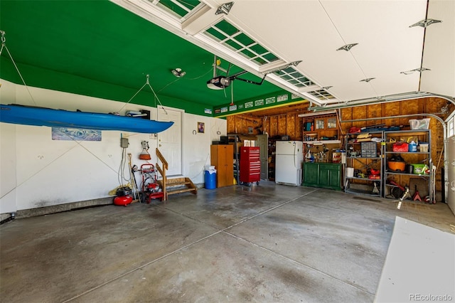 garage featuring freestanding refrigerator and a garage door opener