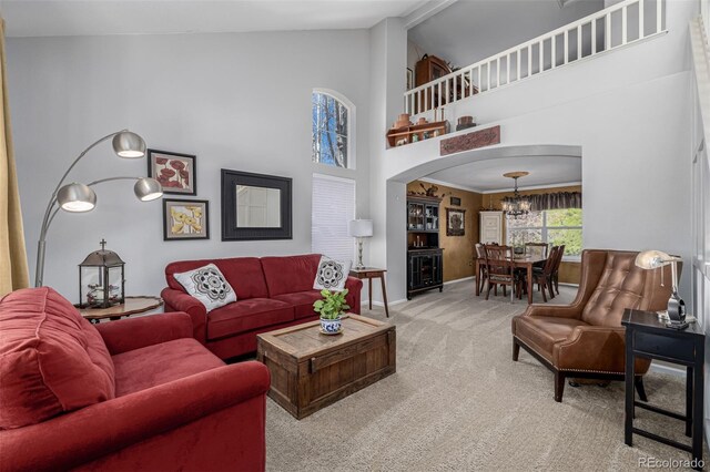 living room featuring high vaulted ceiling, carpet floors, arched walkways, a chandelier, and baseboards